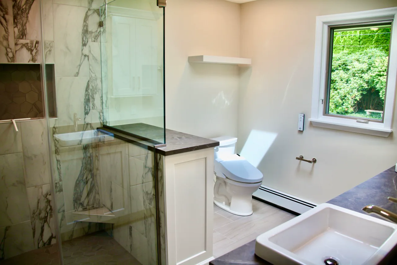 Marble walk-in shower with glass enclosure and custom tile work by Mac Kitchens in the Lehigh Valley